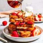 Pouring maple syrup over French toast.