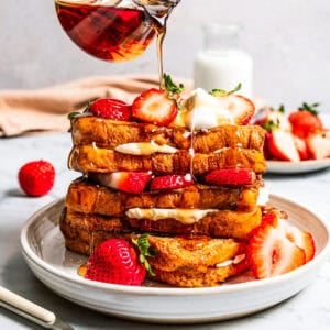 Pouring maple syrup over French toast.
