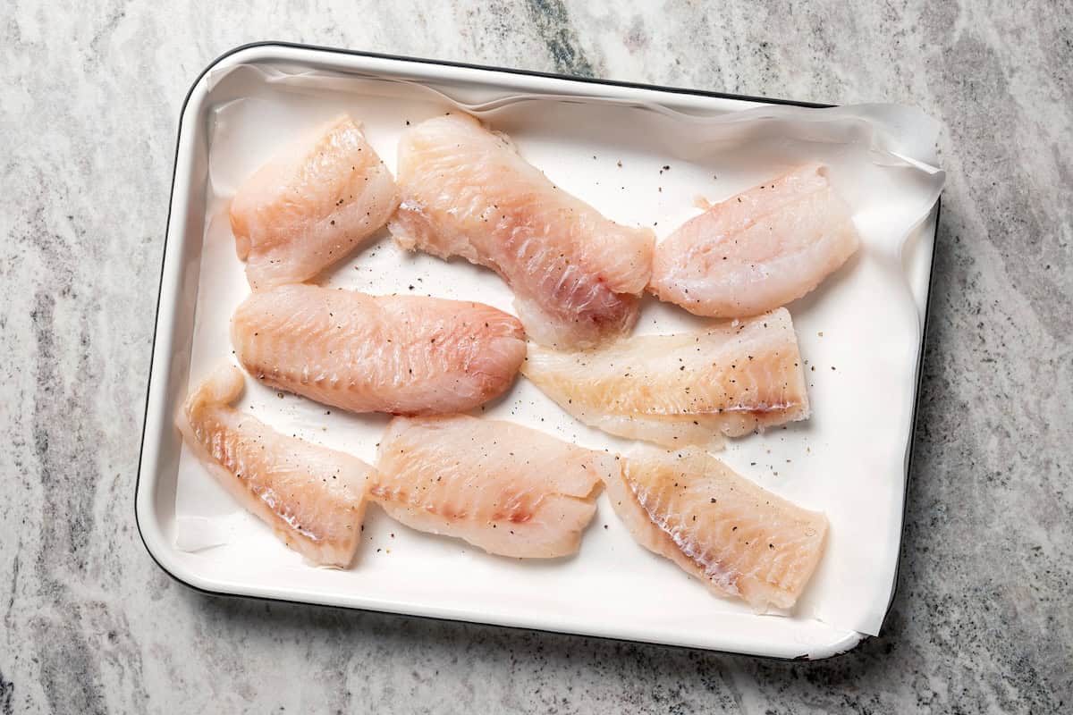 Make beer-battered fish with easy ingredients! This crispy, flaky fried white fish is perfect for tacos, pub-style fish and chips, and more. White fish fillets on a sheet pan.