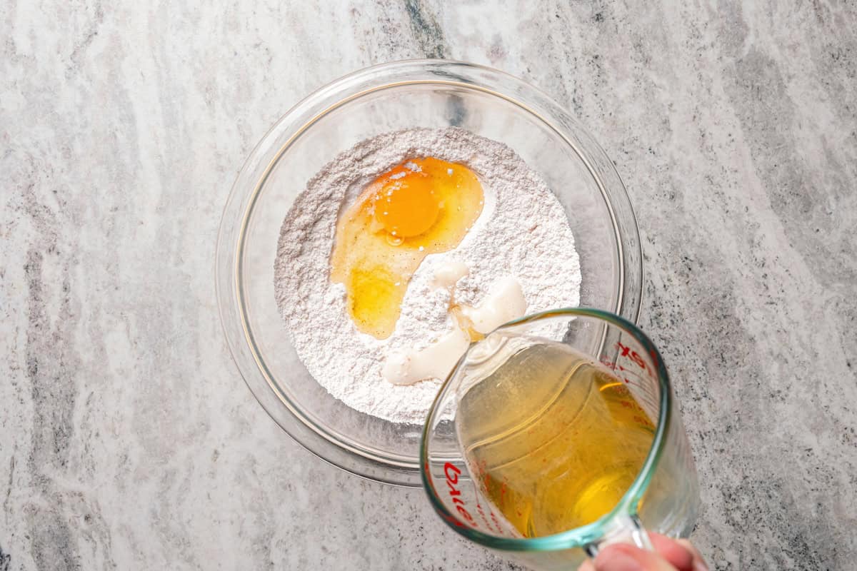 Make beer-battered fish with easy ingredients! This crispy, flaky fried white fish is perfect for tacos, pub-style fish and chips, and more. Pouring beer into a bowl with dry ingredients and an egg to make the batter.