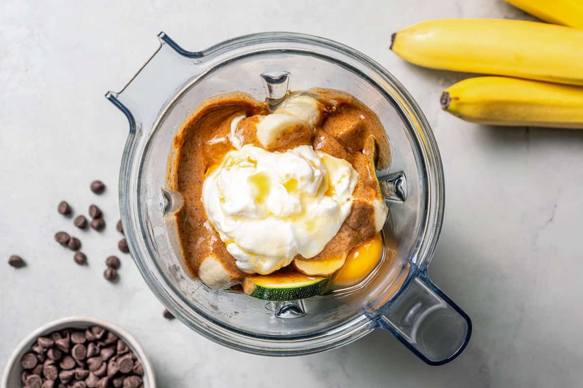 Chocolate protein muffins are moist, loaded with hidden veggies, and easy to make in the blender for a high-protein breakfast or meal prep. Wet protein muffin ingredients combined in a blender.