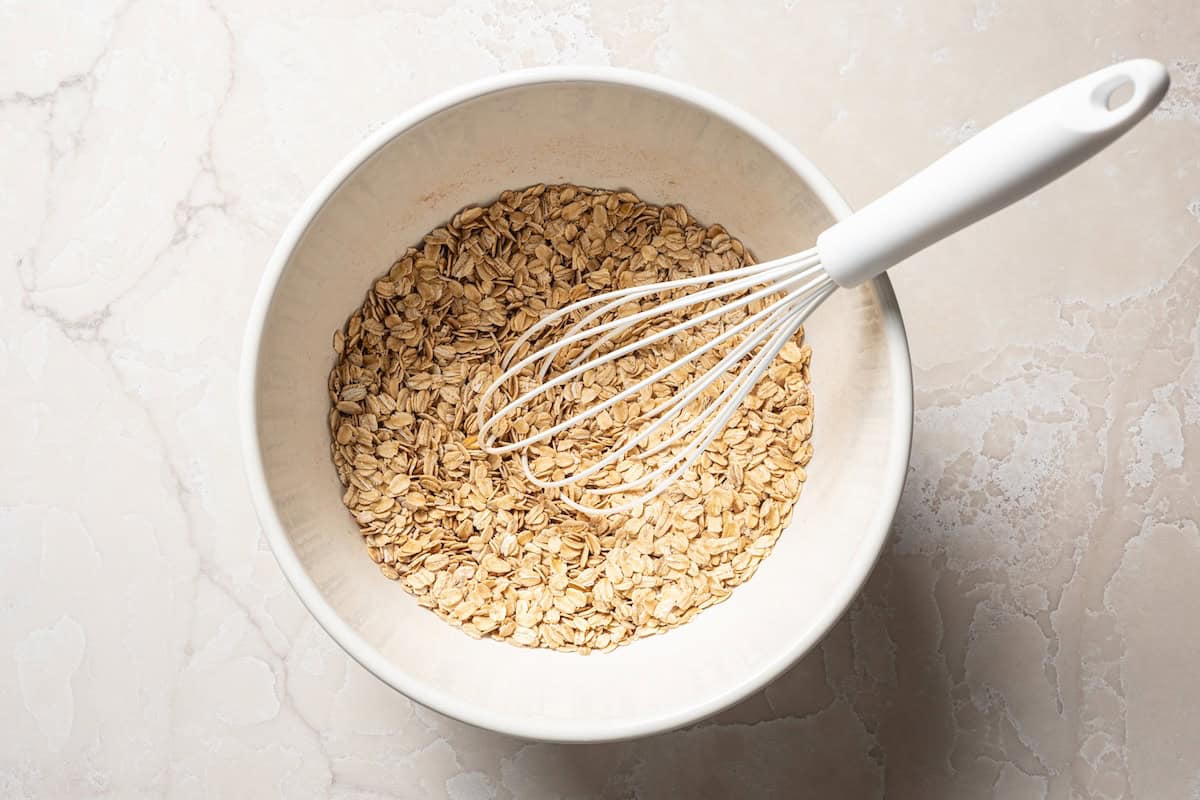 Pumpkin baked oatmeal is the perfect easy, make-ahead fall breakfast! Filled with hearty oats, warm spices, pumpkin purée, and maple syrup. Dry oat mixture whisked together in a bowl.