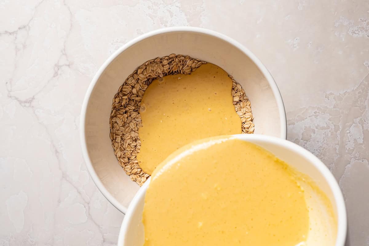 Pumpkin baked oatmeal is the perfect easy, make-ahead fall breakfast! Filled with hearty oats, warm spices, pumpkin purée, and maple syrup. Wet ingredients added to the dry oat mixture in a mixing bowl.