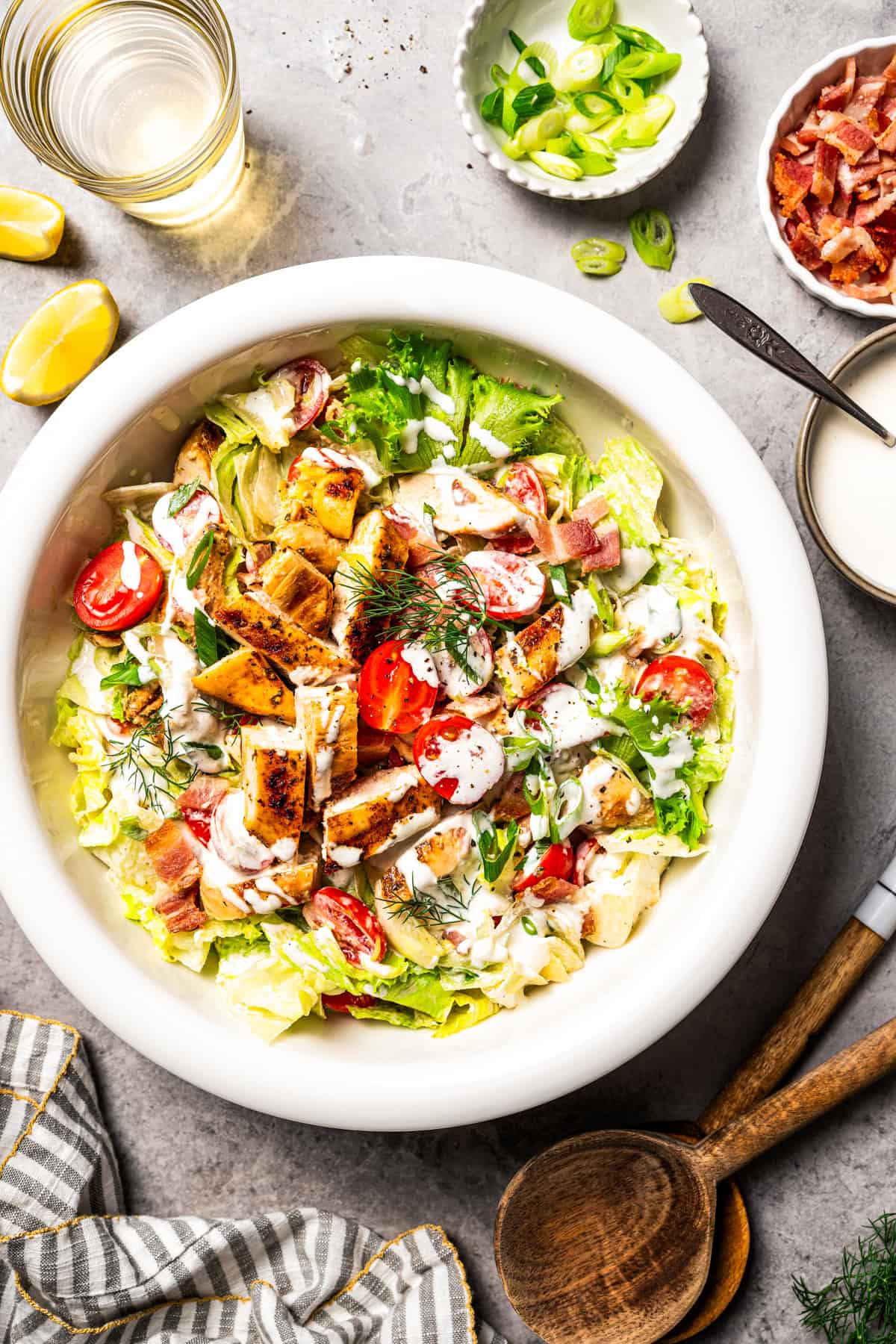 This easy BLT chicken salad combines juicy grilled chicken, crispy bacon, and ripe tomatoes with fresh lettuce and creamy yogurt dressing. BLT chicken salad drizzled with creamy dressing in a bowl.