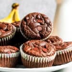 Homemade chocolate protein muffins stacked on a plate.
