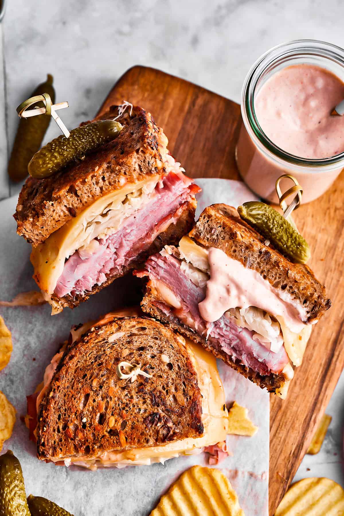Weekly Meal Plan Homemade Reuben sandwiches arranged on a wooden board.