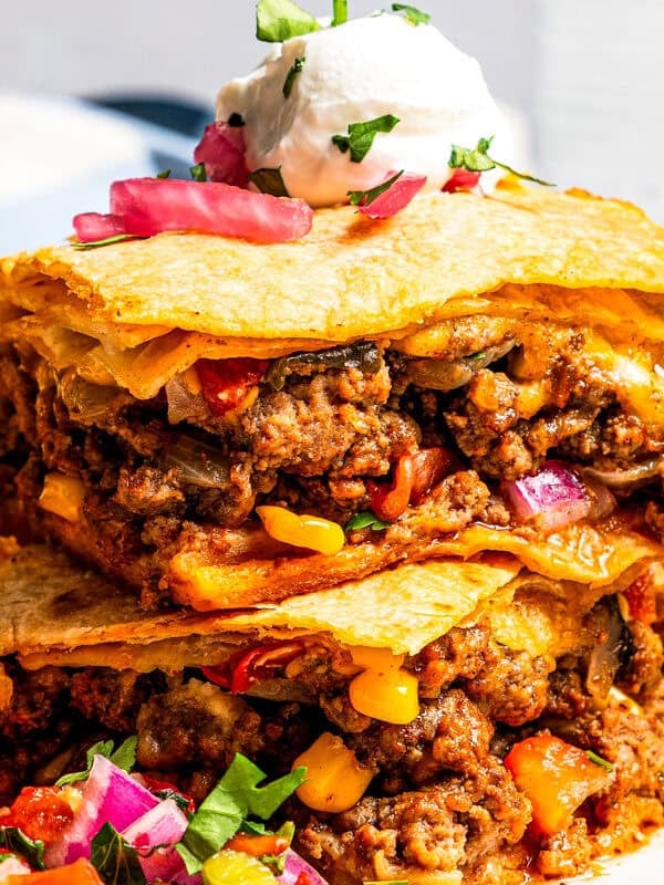 Close-up of sheet pan tacos made with flour tortillas, ground beef, cheese, corn, and peppers.