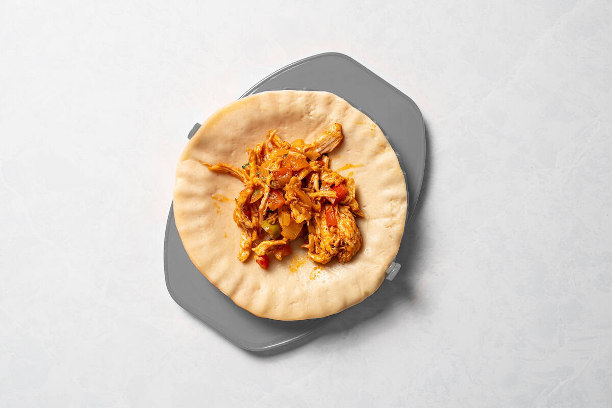 Chicken filling added to a circle of empanada dough.