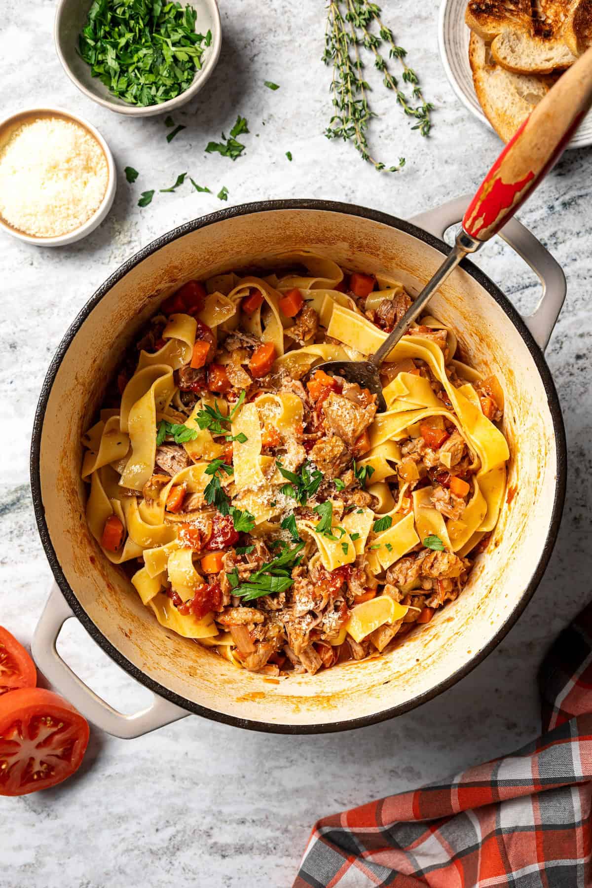 This slow-braised pork ragu recipe cooks for hours in the oven until fall-apart tender and ready to shred into a rich, flavorful meat sauce. Pappardelle noodles tossed with homemade pork ragu in a pot.