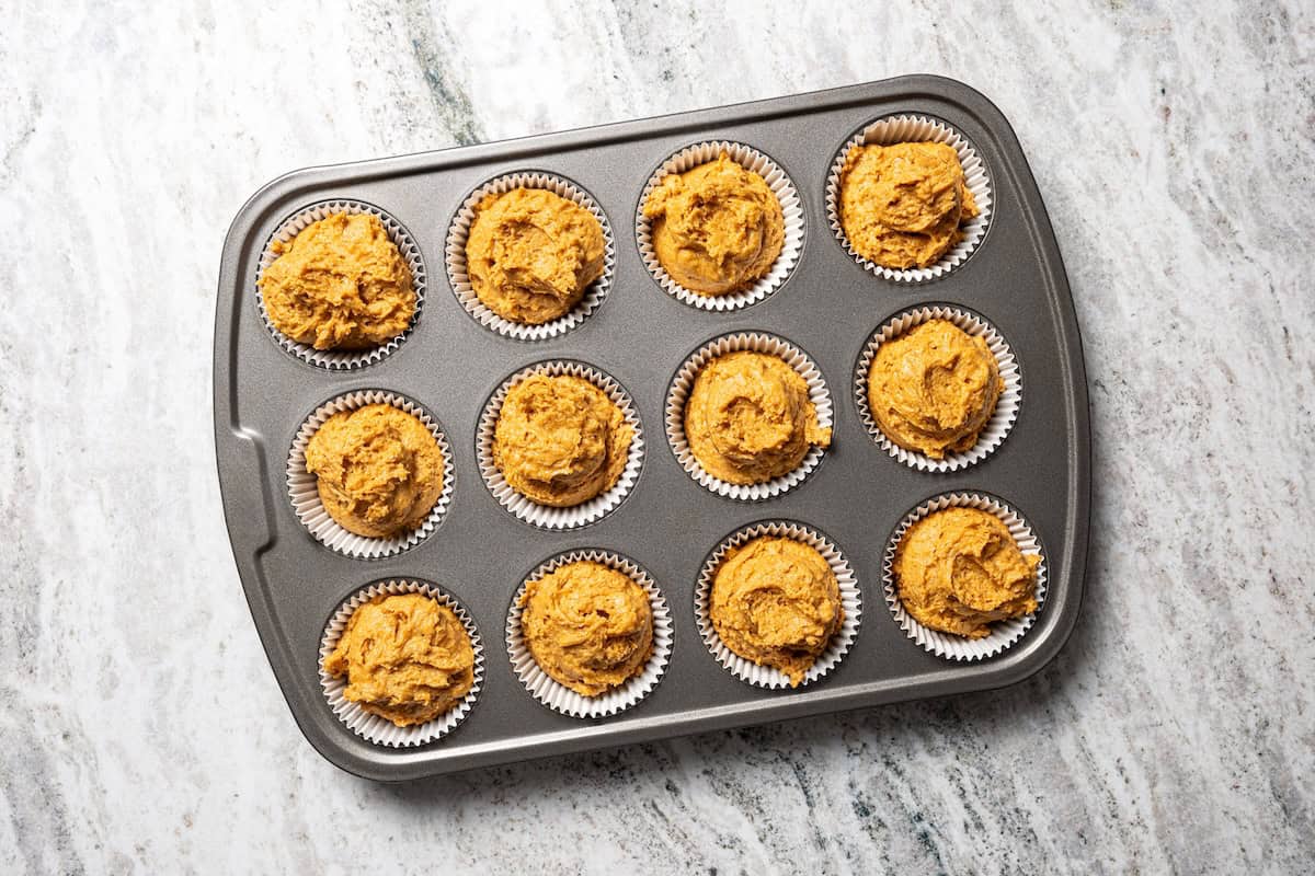 Moist, fluffy pumpkin protein muffins are a high-protein fall treat made with vanilla whey powder, Greek yogurt, eggs, and pumpkin purée. Pumpkin muffin batter ready to bake.