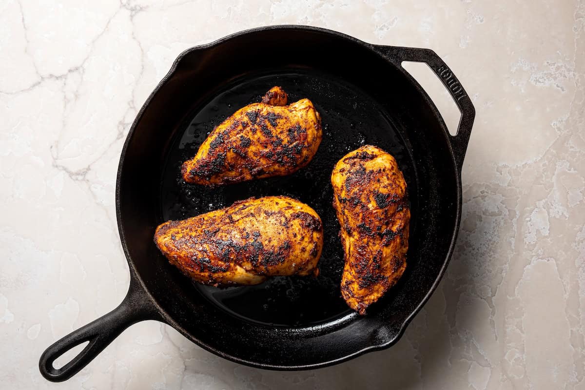 Cooked chicken breasts in a skillet.