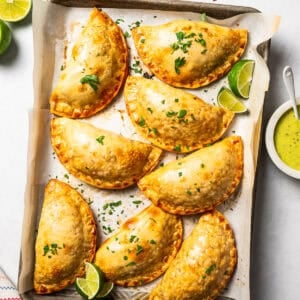 Overhead view of chicken empanadas on a baking sheet.
