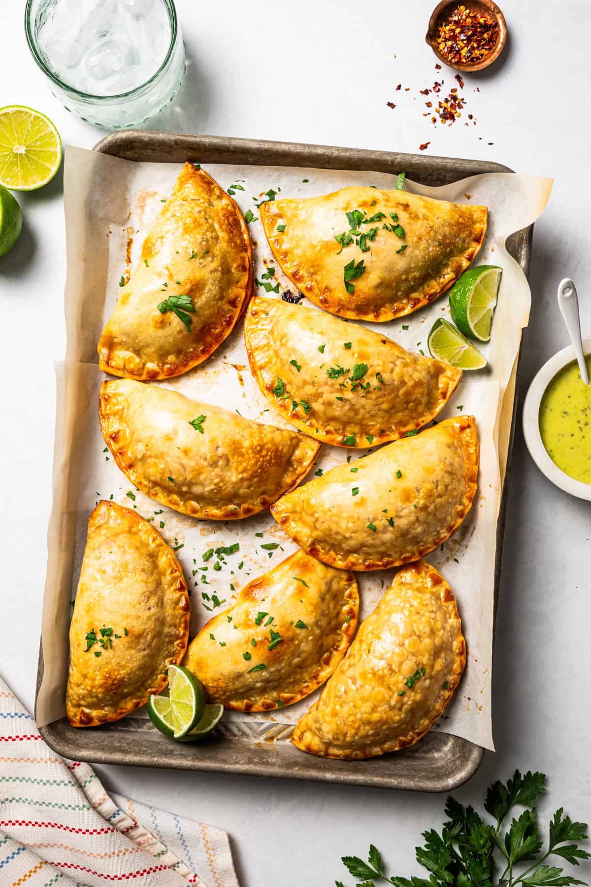 Overhead view of chicken empanadas on a baking sheet.