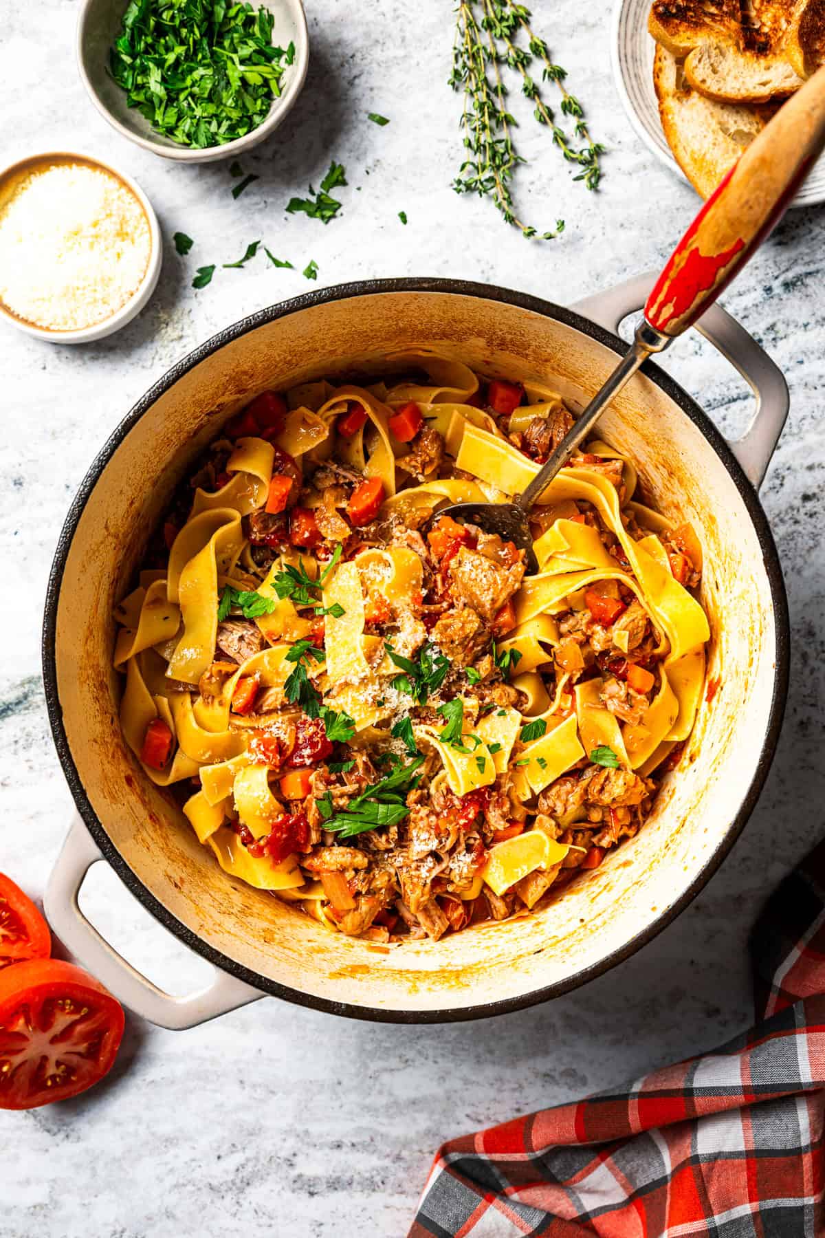 This slow-braised pork ragu recipe cooks for hours in the oven until fall-apart tender and ready to shred into a rich, flavorful meat sauce. Pork ragu sauce with pappardelle pasta in a cooking pot.