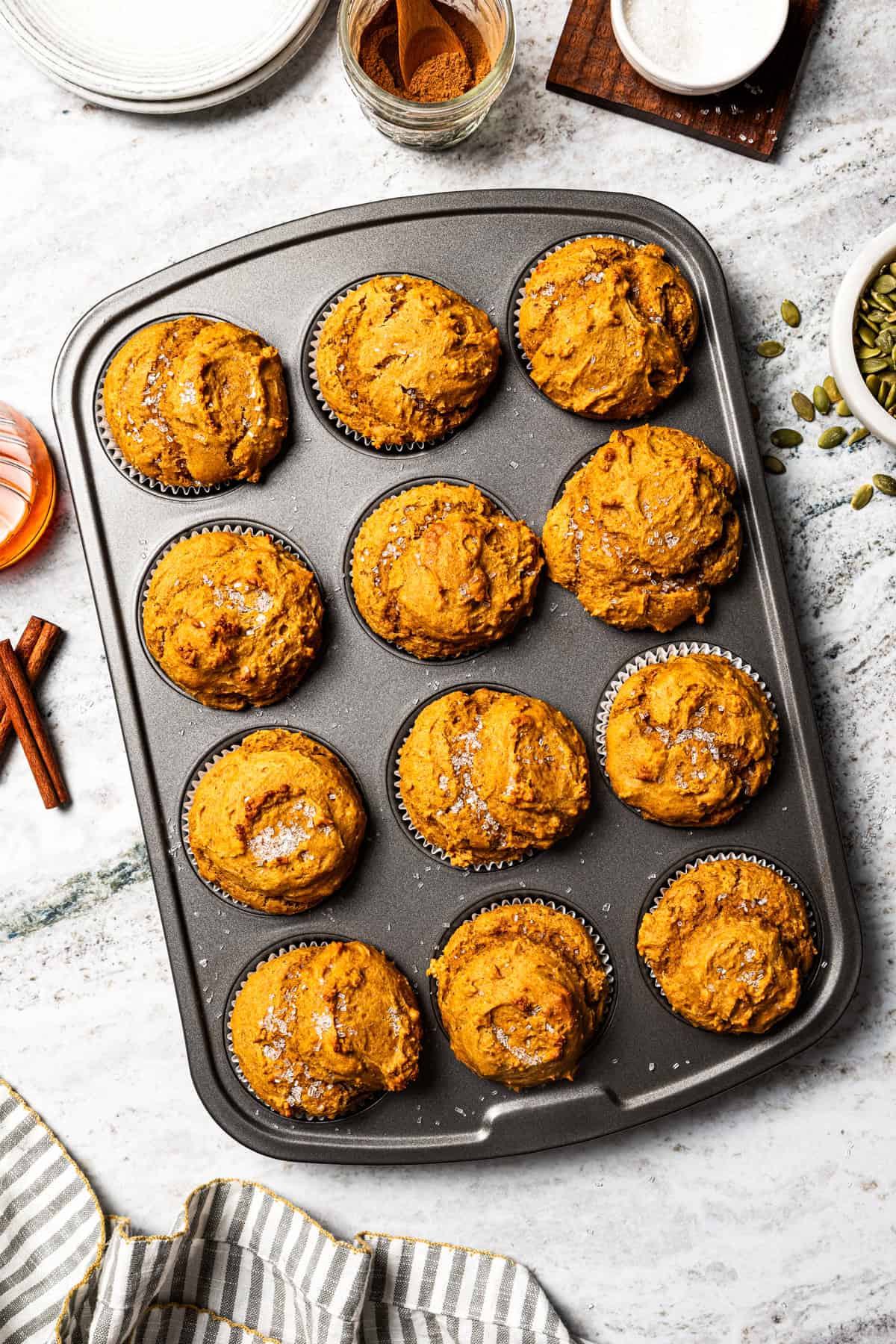 Moist, fluffy pumpkin protein muffins are a high-protein fall treat made with vanilla whey powder, Greek yogurt, eggs, and pumpkin purée. Freshly baked protein pumpkin muffins in a muffin pan topped with coarse sugar.