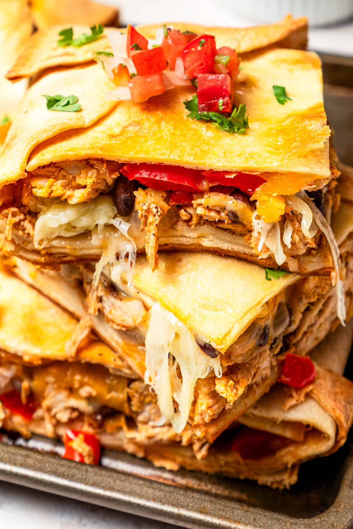 Two servings of quesadillas stacked up on a plate.