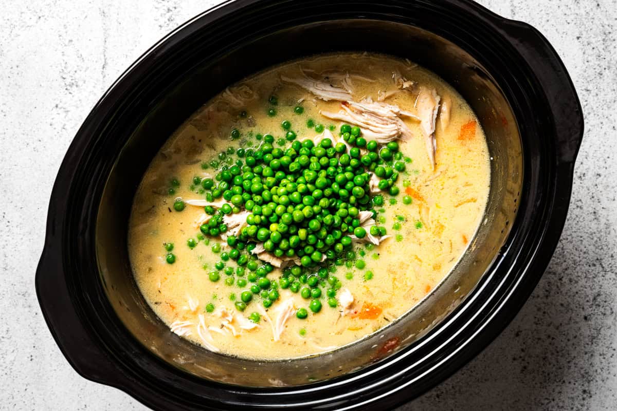 This slow cooker chicken and dumplings recipe is a cozy, creamy chicken stew loaded with homemade biscuit dumplings. All cooked in one pot! Shredded chicken and green peas stirred into the creamy filling for slow cooker chicken and dumplings.