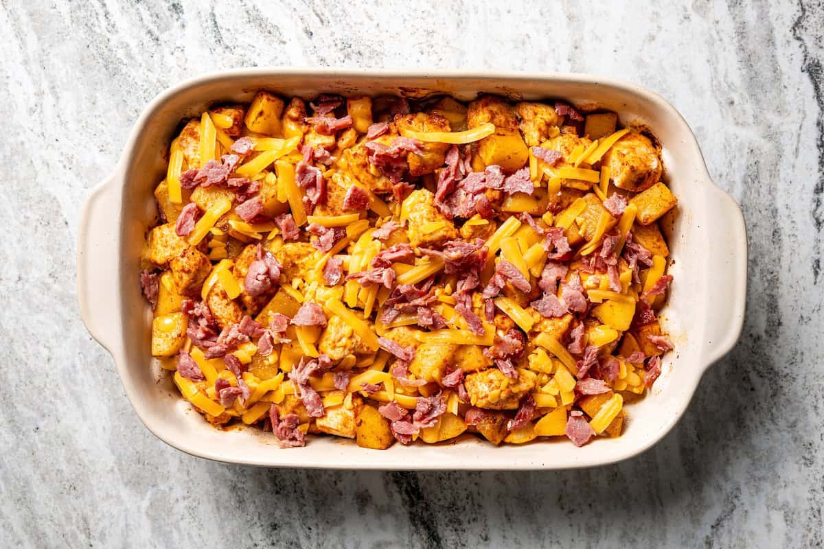 This chicken potato casserole combines juicy seasoned chicken and potatoes, baked in one pan and loaded with bacon, cheese, and sour cream. Baked chicken potato casserole topped with bacon.