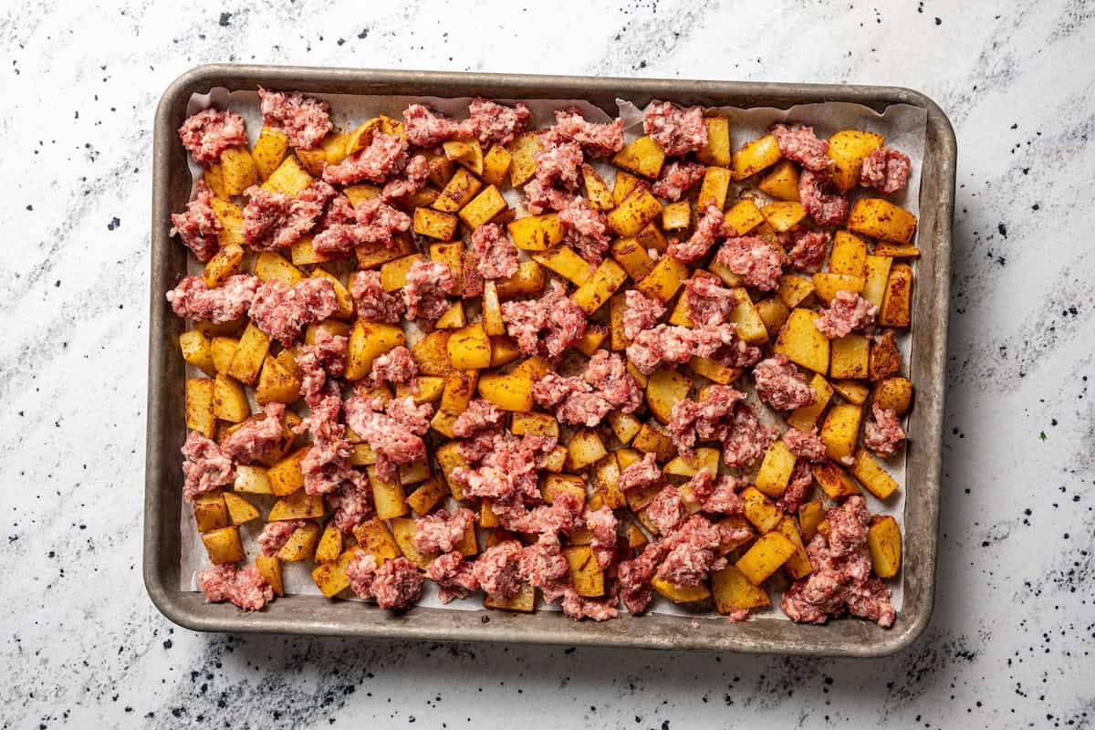 Sheet pan breakfast burritos are an easy way to batch-make breakfast burritos! Bake the filling in one pan, then roll it into soft tortillas. Crumbled sausage added to a sheet pan with roasted potatoes.
