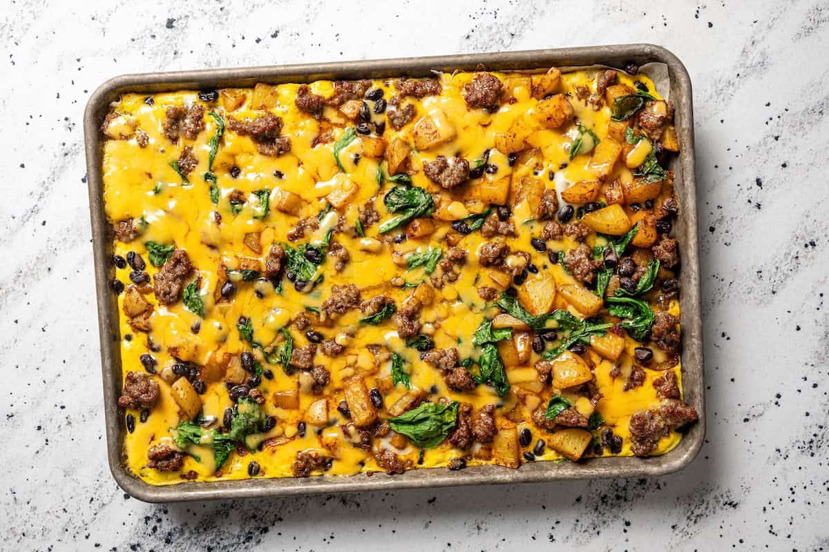 Sheet pan breakfast burritos are an easy way to batch-make breakfast burritos! Bake the filling in one pan, then roll it into soft tortillas. Finished breakfast burritos filling on a sheet pan.