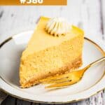 A slice of instant pot pumpkin cheesecake served on a dessert plate, with a fork set right next to it.