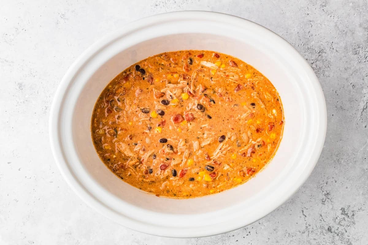 Thick and creamy Buffalo chicken chili made with shredded chicken, beans, Buffalo sauce, and cream cheese. An easy crockpot chili, perfect for weeknights or game day! Creamy chicken chili with beans, corn, tomatoes, and shredded chicken in a slow cooker.