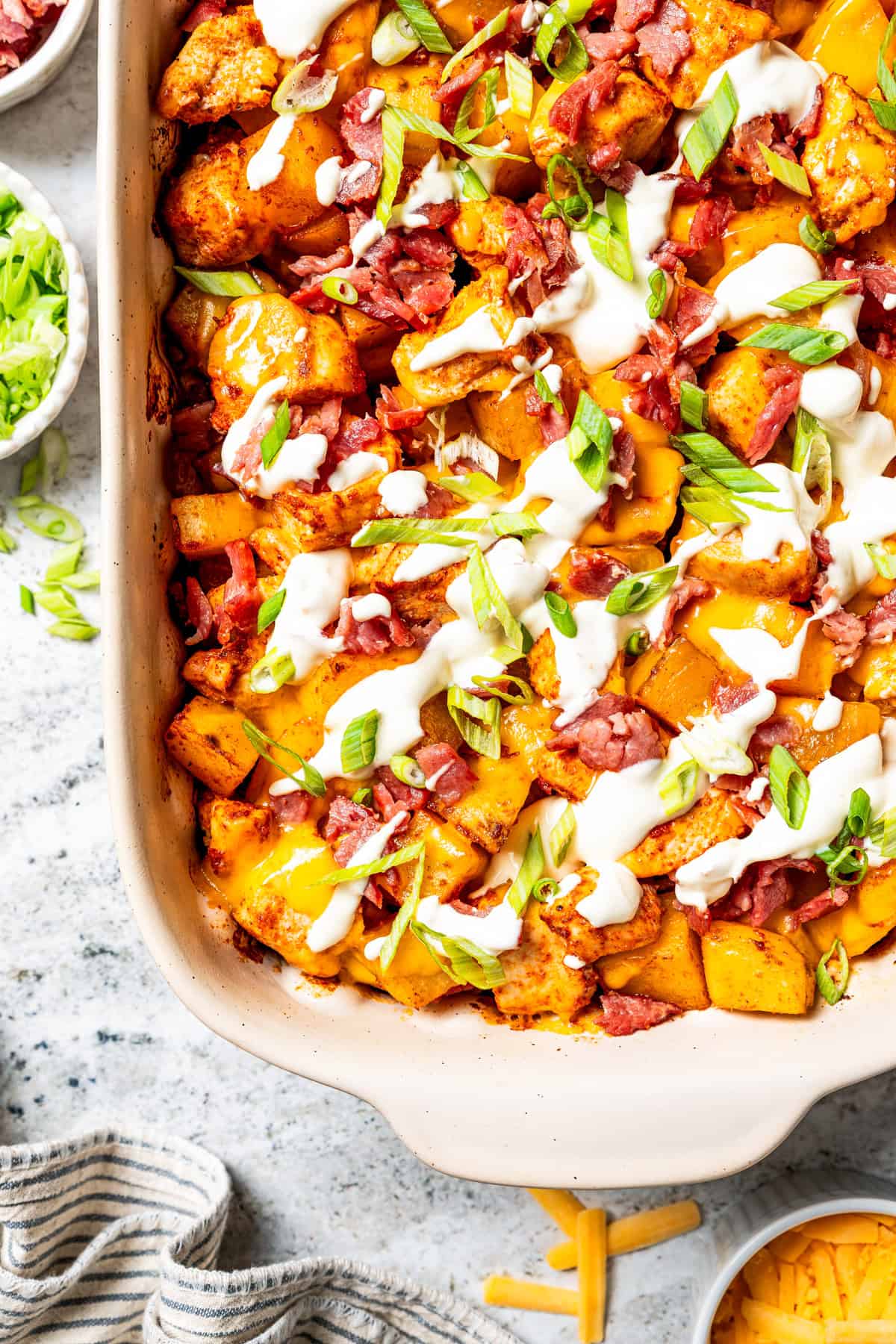 This chicken potato casserole combines juicy seasoned chicken and potatoes, baked in one pan and loaded with bacon, cheese, and sour cream. Chicken potato casserole in a baking dish.