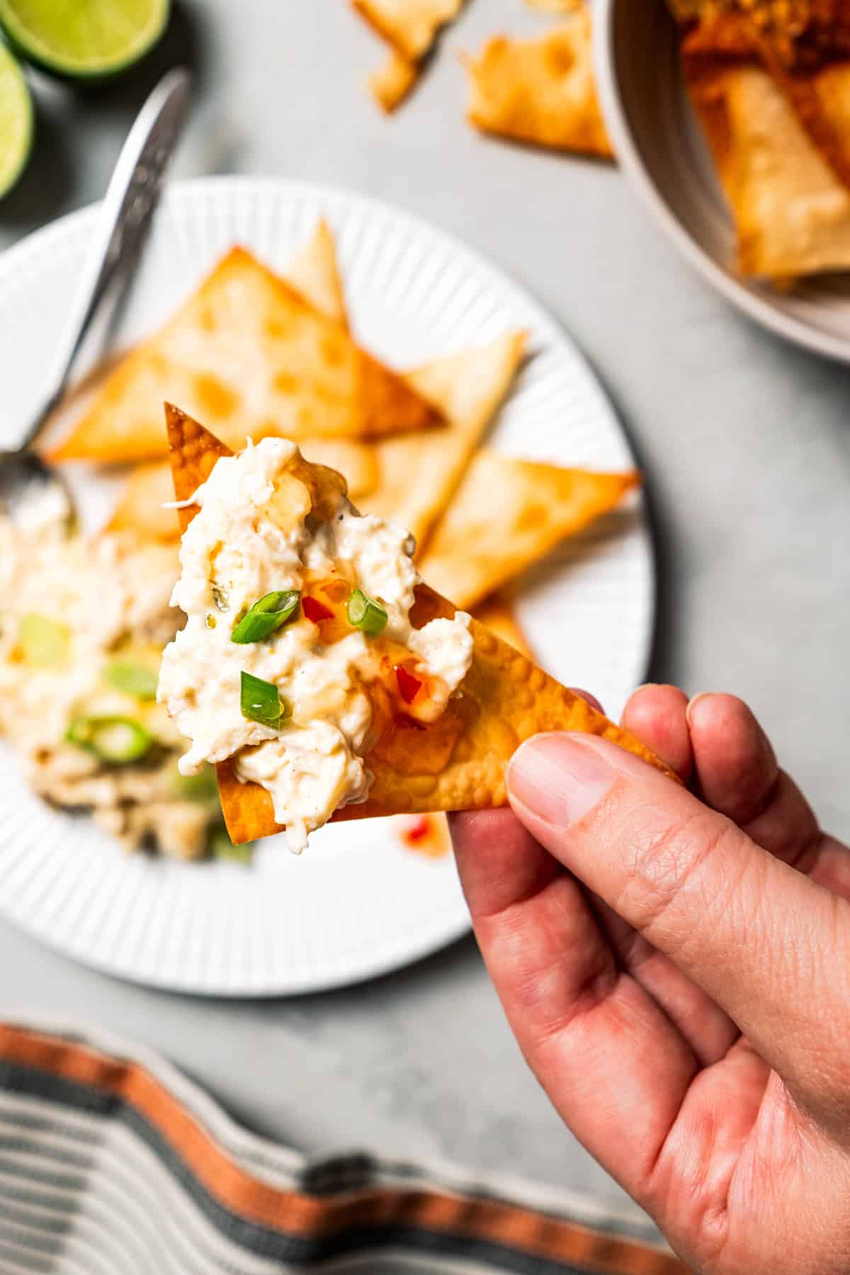 Crab rangoon dip has all those creamy flavors in an easy baked crab dip with cream cheese, sweet chili, green onion, and crispy wonton chips. Crispy wonton chip topped with creamy crab rangoon dip.