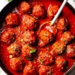 A skillet of porcupine meatballs simmering in tomato sauce.