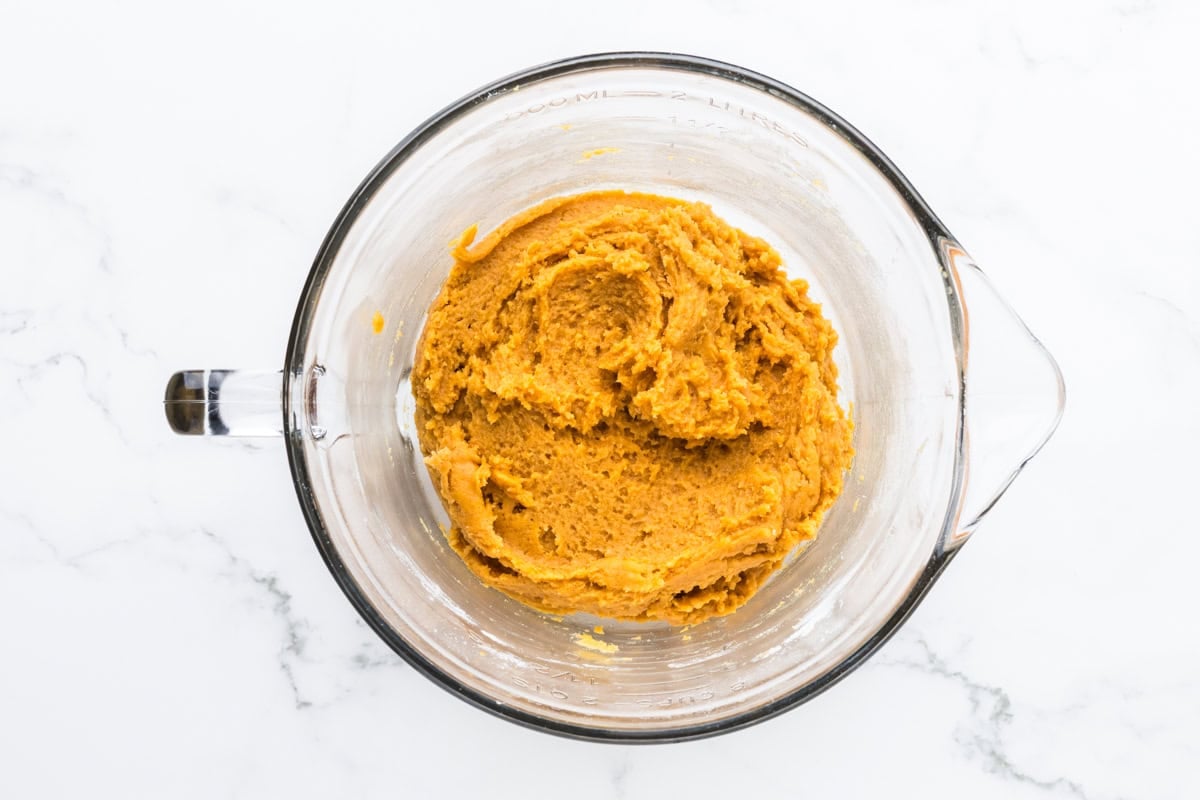 Thick pumpkin spice biscotti dough mixed in a glass measuring cup.