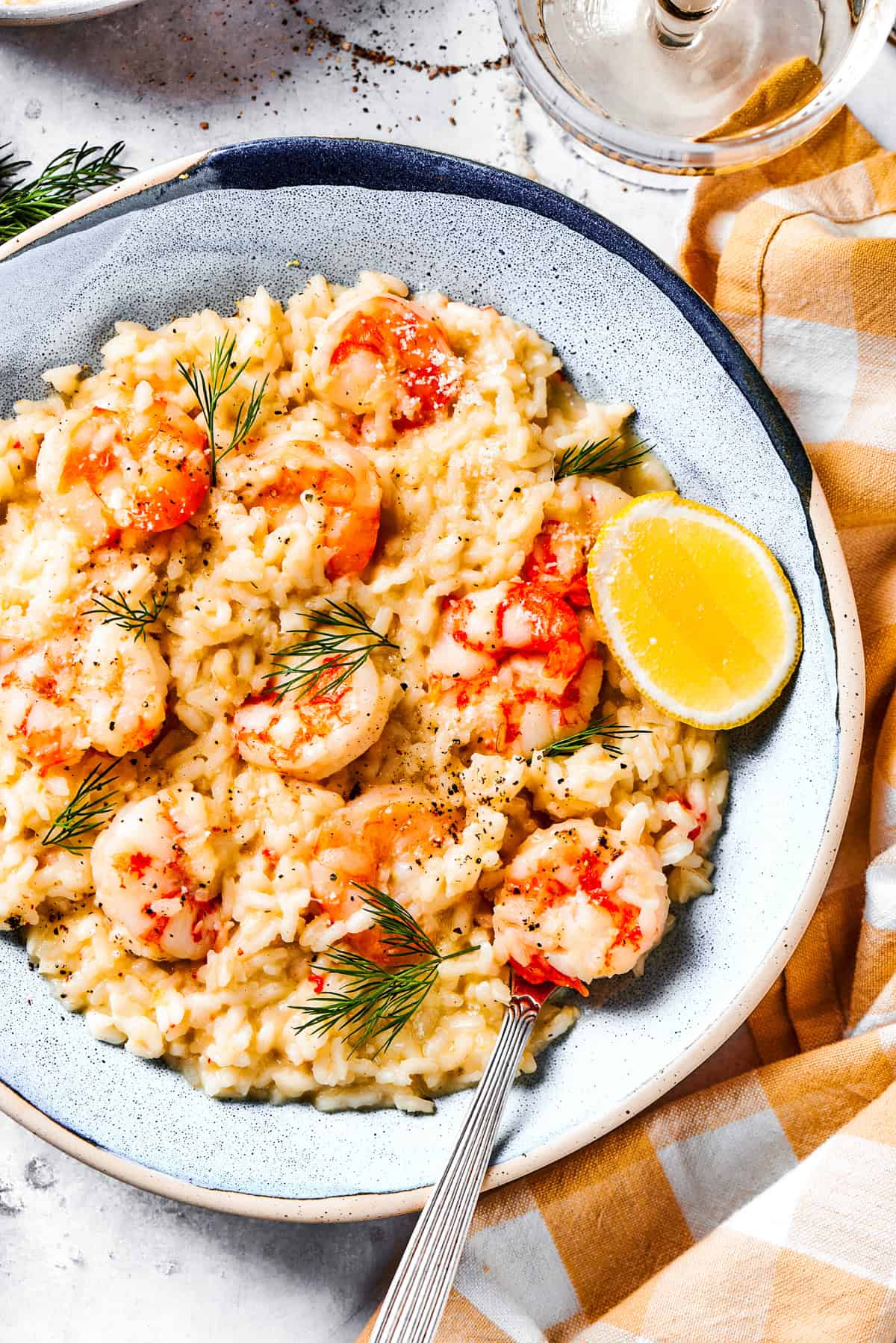 Weekly Meal Plan A bowl of creamy risotto topped with shrimp and a lemon wedge.